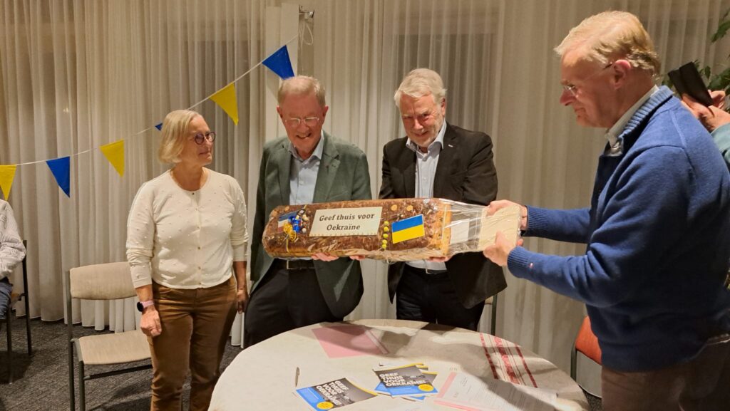 Loes Pieper (l) en Rijk Wibbelink (r) overhandigen een krentenwegge aan Robert Serry en Rits Dijkstra van ODU.